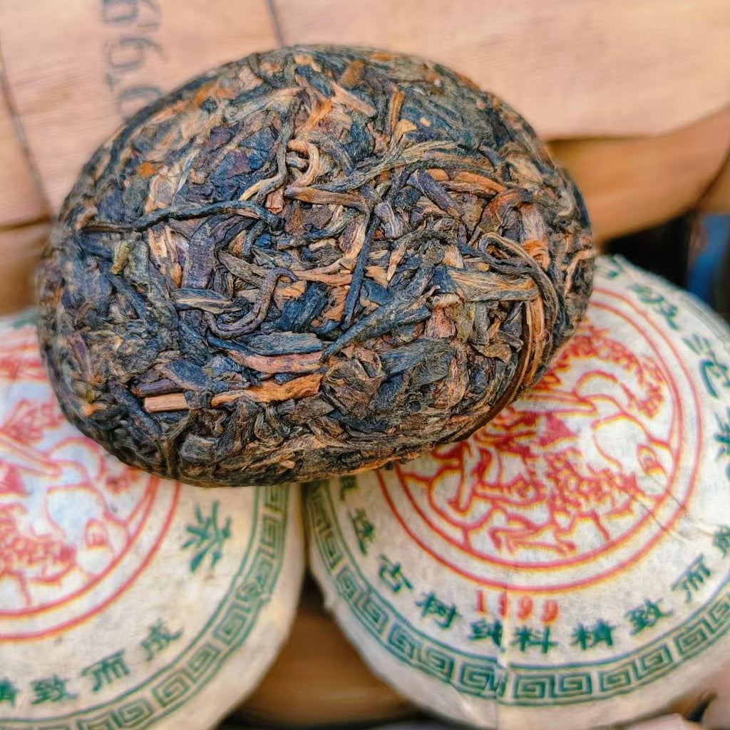 Close-up of a raw pu-erh compressed tea ball on a stack of similar tea balls 