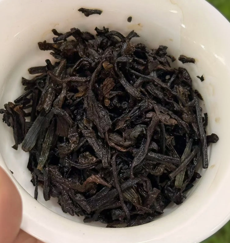 Dry black tea leaves in a white bowl