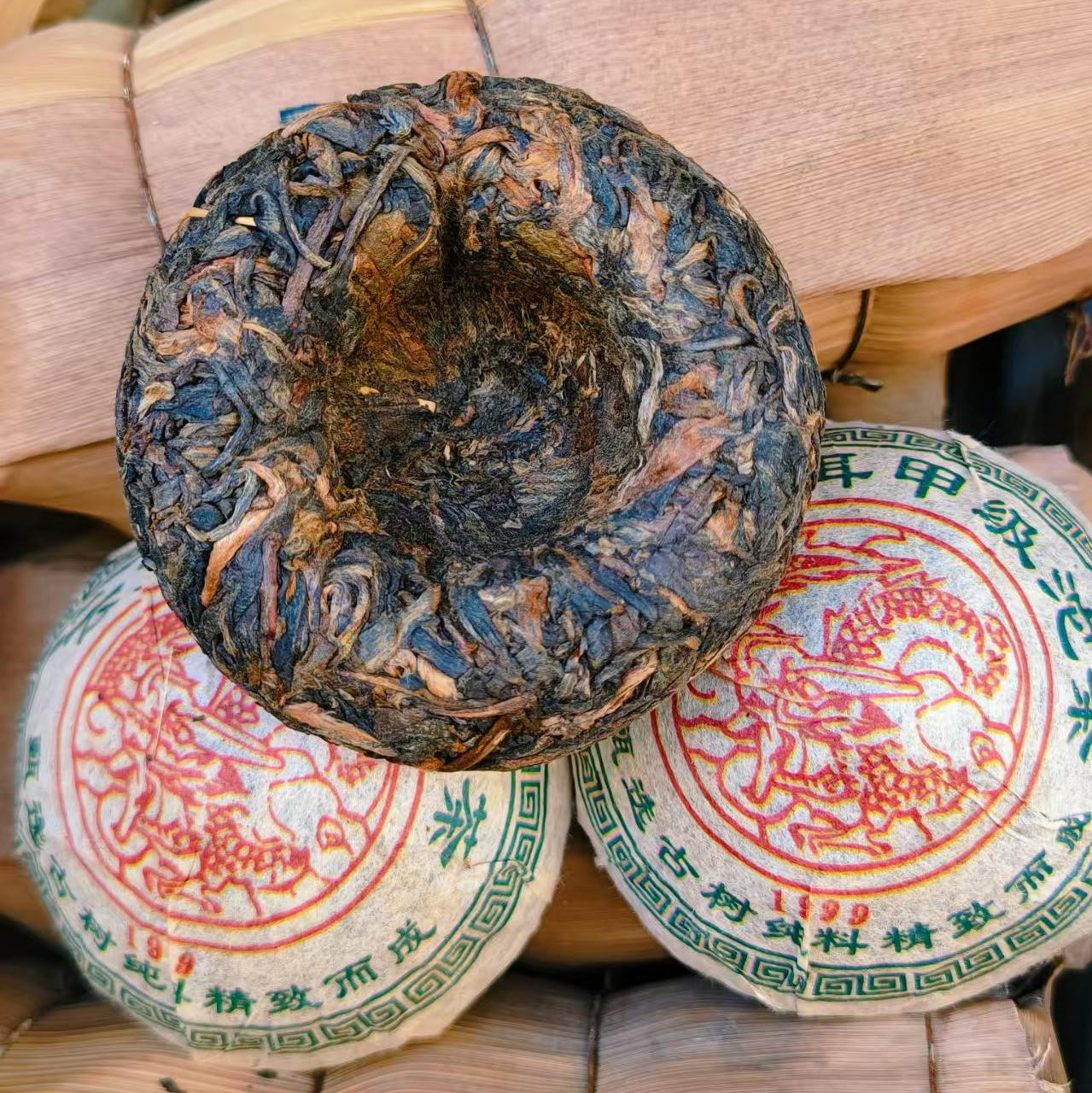 Traditional Chinese tea cake with red and green labels on a woven bamboo basket background